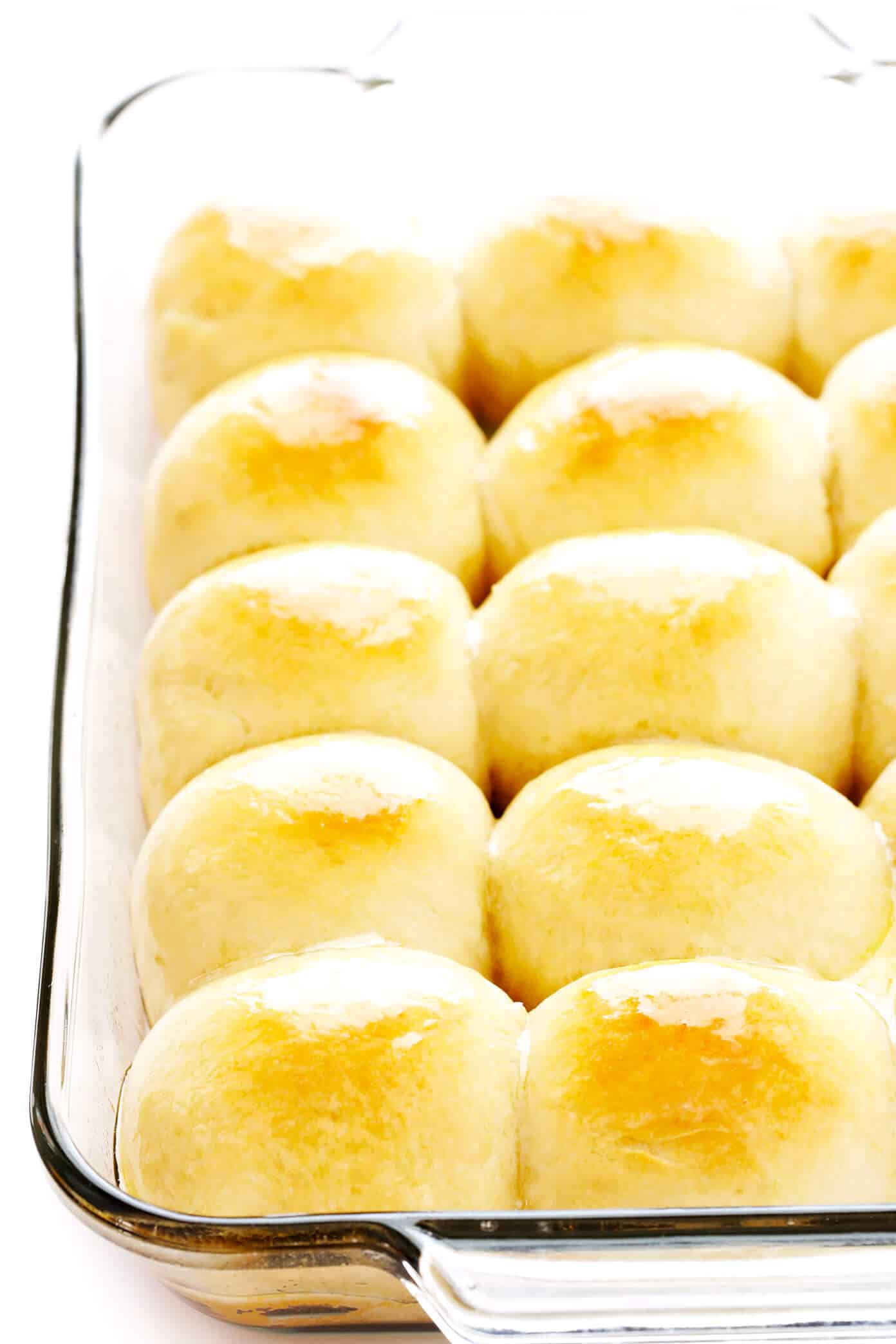 My favorite 1-Hour Soft and Buttery Dinner Rolls recipe is easy to make by hand or with a stand mixer, perfectly soft and fluffy, and so buttery and delicious! Options to make them with garlic, herbs, or extra-cheesy included too! | gimmesomeoven.com #dinner #rolls #buns #side #thanksgiving #christmas #bread #holidays #bake 1-Hour Dinner Rolls Recipe in Baking Dish