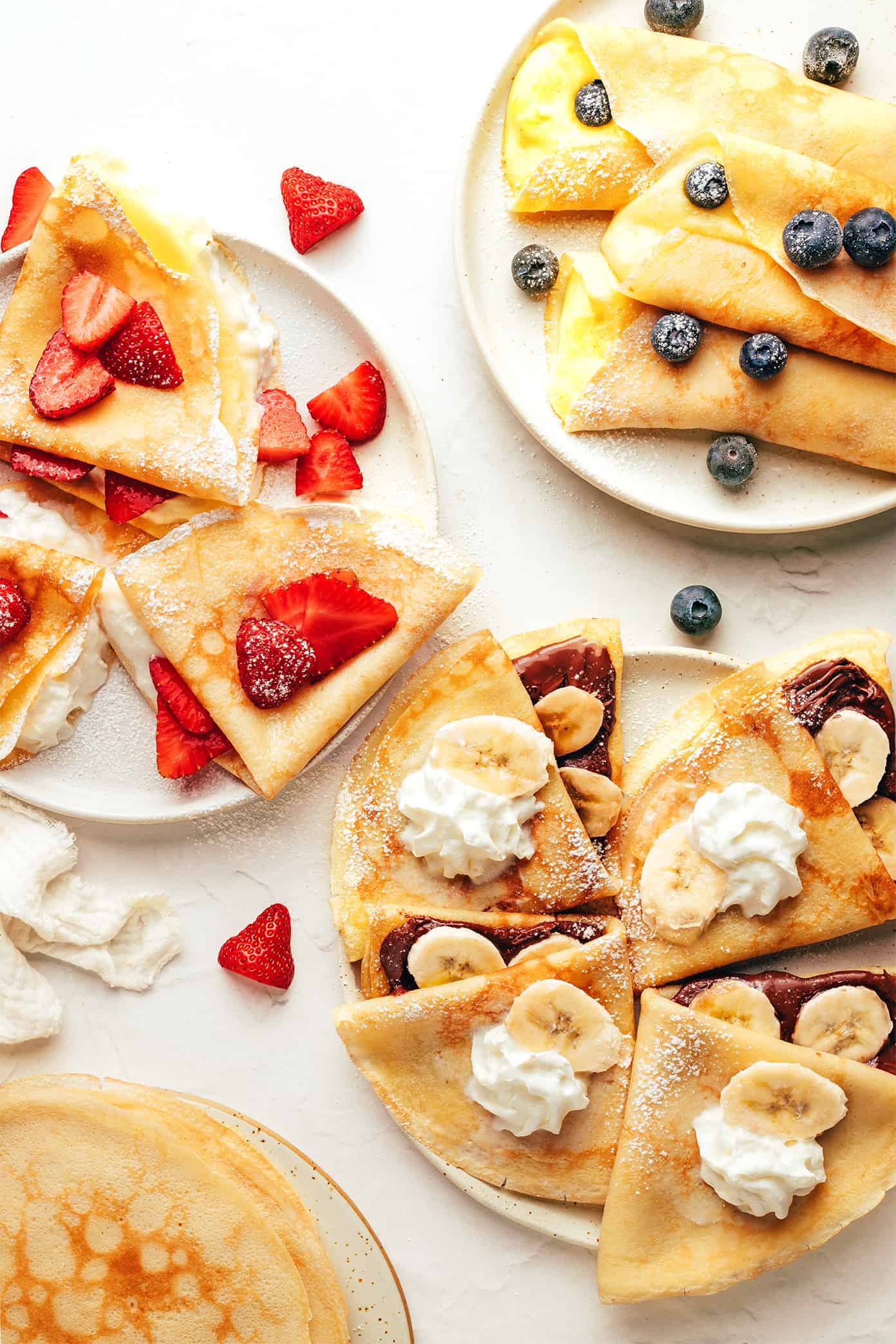 This classic French crepe recipe is easy to make in the blender with 7 basic ingredients. Always such a lovely, simple recipe for breakfast or brunch. Feel free to customize with your favorite sweet or savory fillings! | gimmesomeoven.com Assortment of homemade crepes