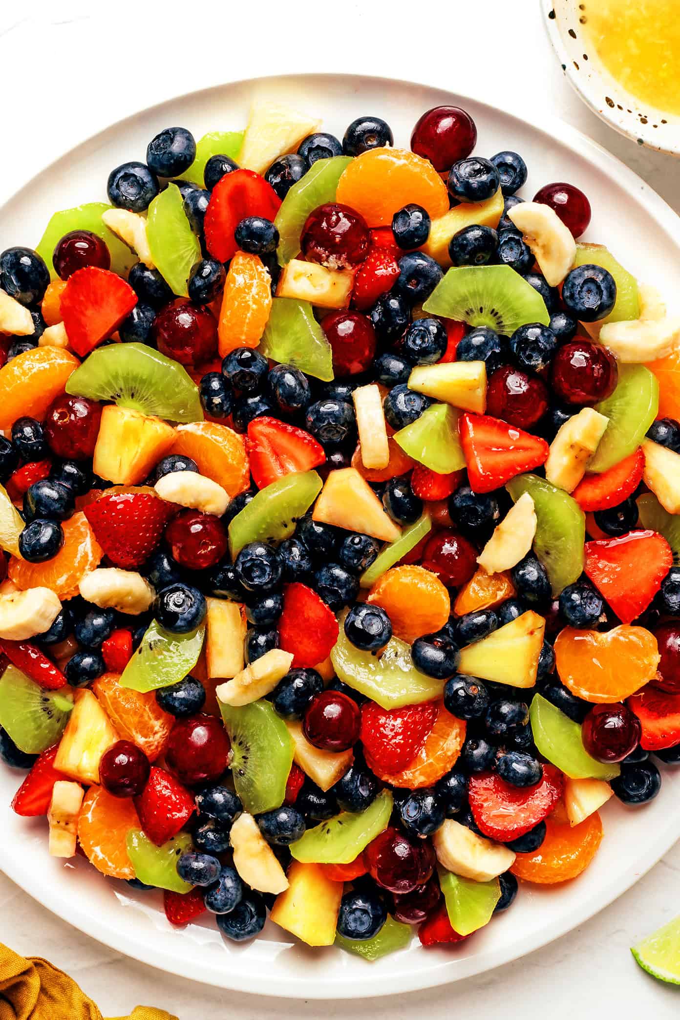 This easy fruit salad recipe features a rainbow mix of fresh fruit tossed in a zippy ginger-lime dressing. It's the perfect colorful side dish for picnics, potlucks or summer dinners! | gimmesomeoven.com Favorite Fruit Salad