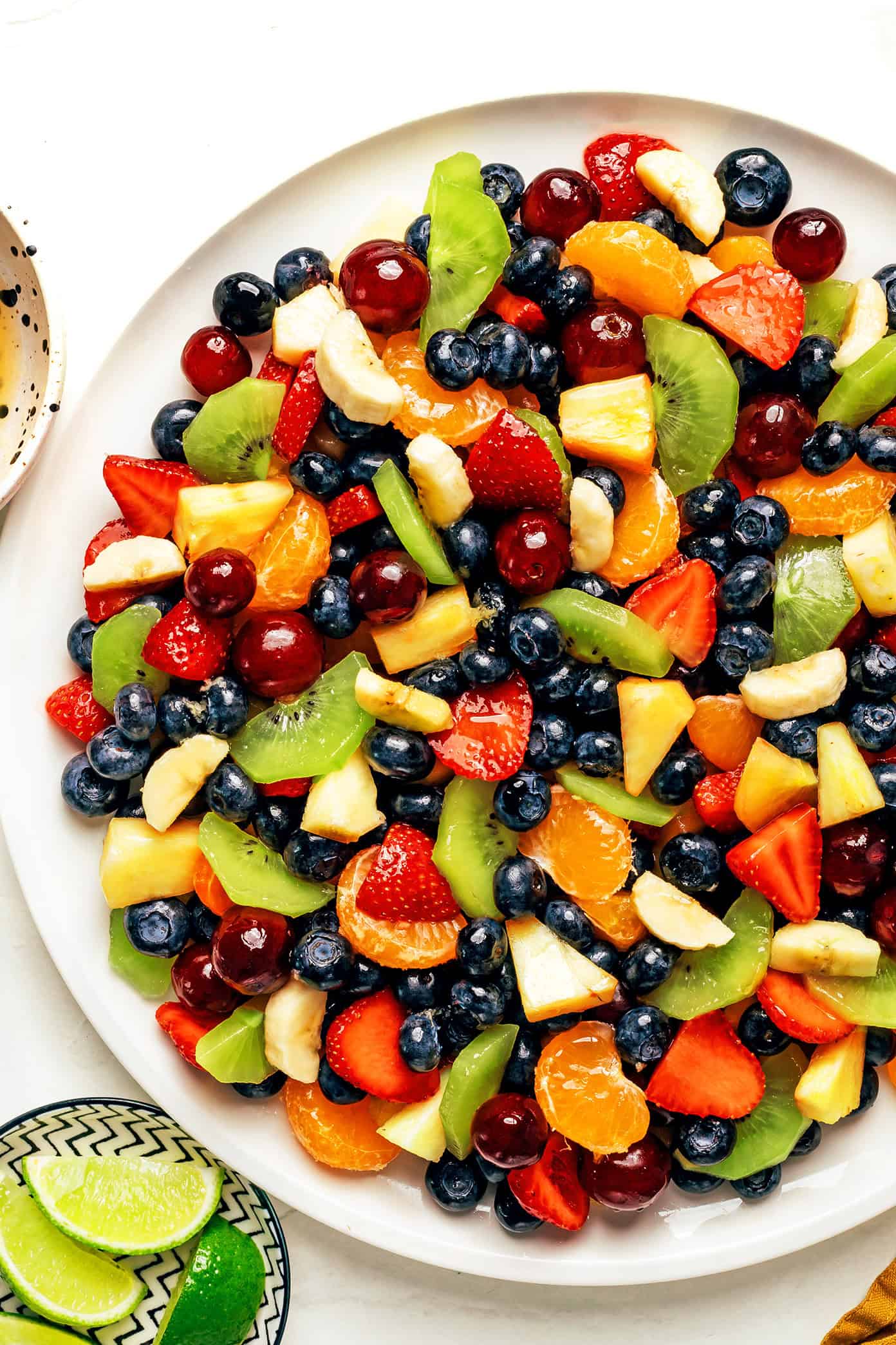 This easy fruit salad recipe features a rainbow mix of fresh fruit tossed in a zippy ginger-lime dressing. It's the perfect colorful side dish for picnics, grill nights or summer dinners! | gimmesomeoven.com fruit salad with ginger lime dressing
