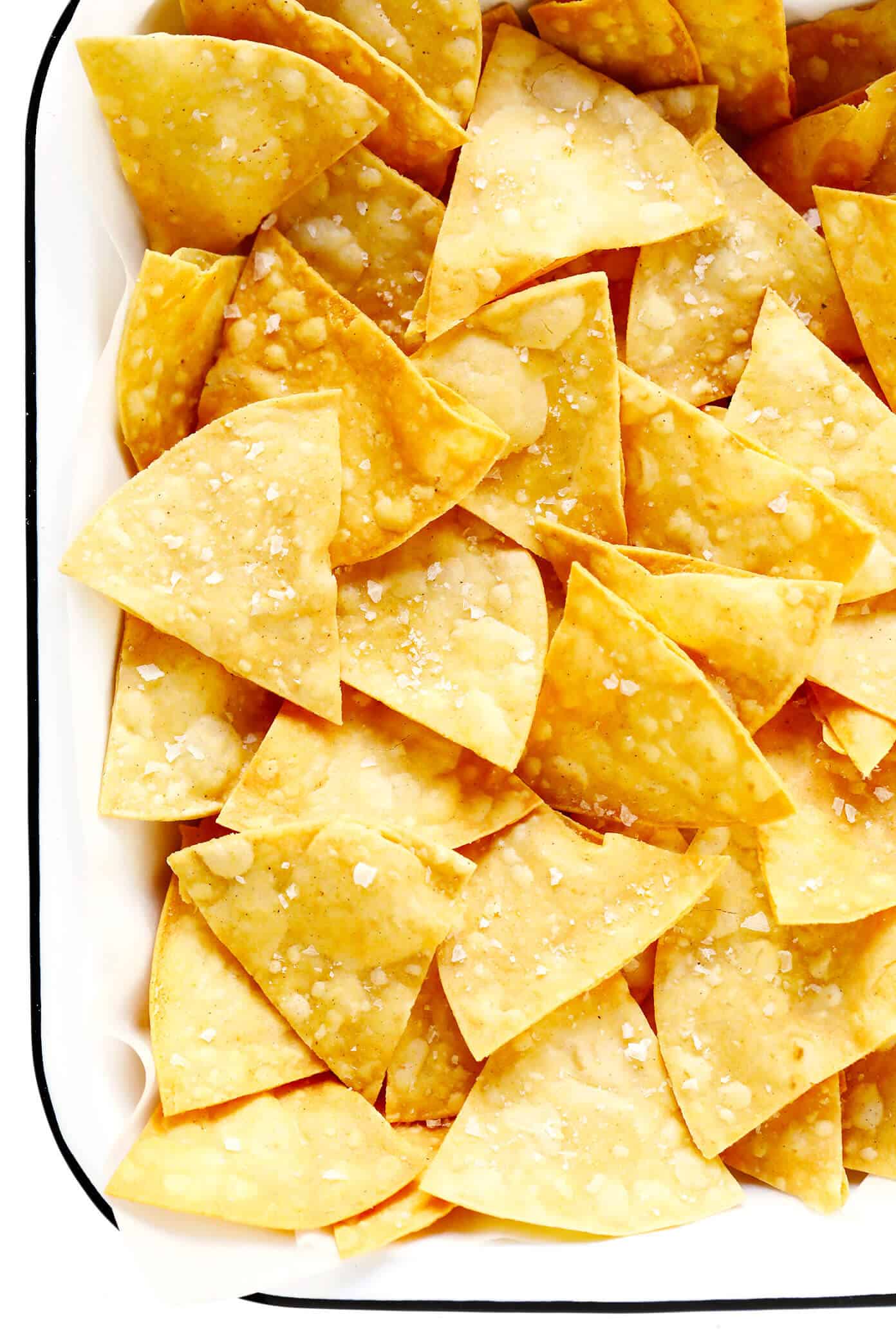 This homemade tortilla chips recipe is easy to make with 3 basic ingredients (corn tortillas, oil and salt) and always SO delicious! | gimmesomeoven.com #homemade #corn #tortilla #chips #glutenfree #vegan #vegetarian #appetizer #gameday #snack Tortilla Chips with Flaky Sea Salt In A Pan