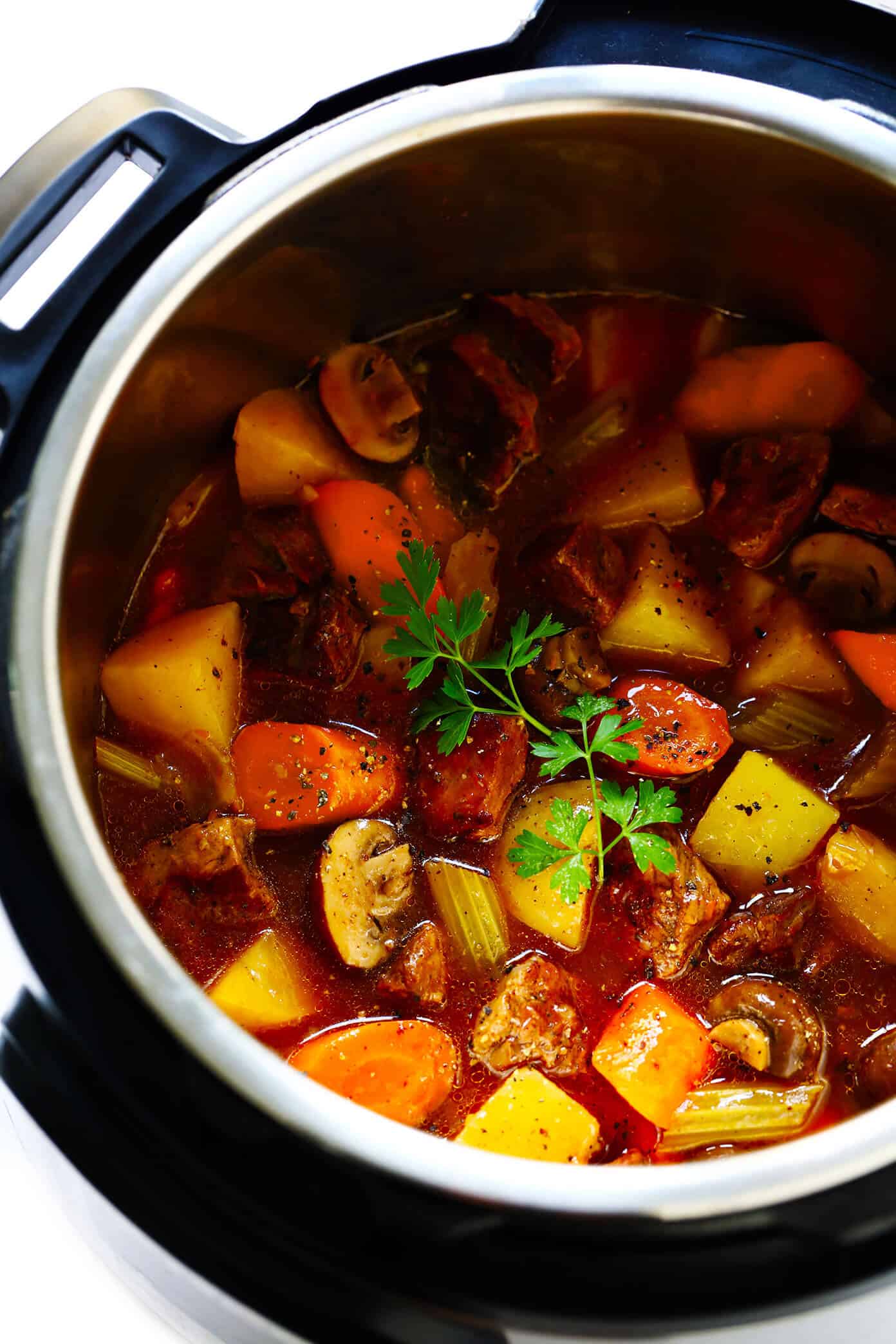 My favorite classic Beef Stew recipe -- full of tender steak, hearty potatoes, carrots, celery, onions, mushrooms and a savory tomato herb gravy. It's easy to make in the Instant Pot (pressure cooker) or Crock Pot (slow cooker), and always SO hearty and delicious. | gimmesomeoven.com #beef #stew #steak #soup #instantpot #crockpot #dinner #mealprep #glutenfree Instant Pot Beef Stew