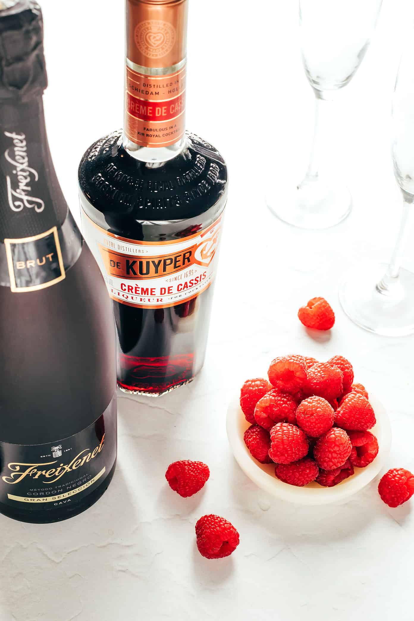 This classic kir royale cocktail recipe is easy to make with dry sparkling wine (such as Champagne, cava or prosecco), crรจme de cassis (blackcurrant liqueur) and your choice of berries for garnish. It's a vibrant, bubbly, refreshing drink that's perfect for summertime! | gimmesomeoven.com Kir Royale Ingredients