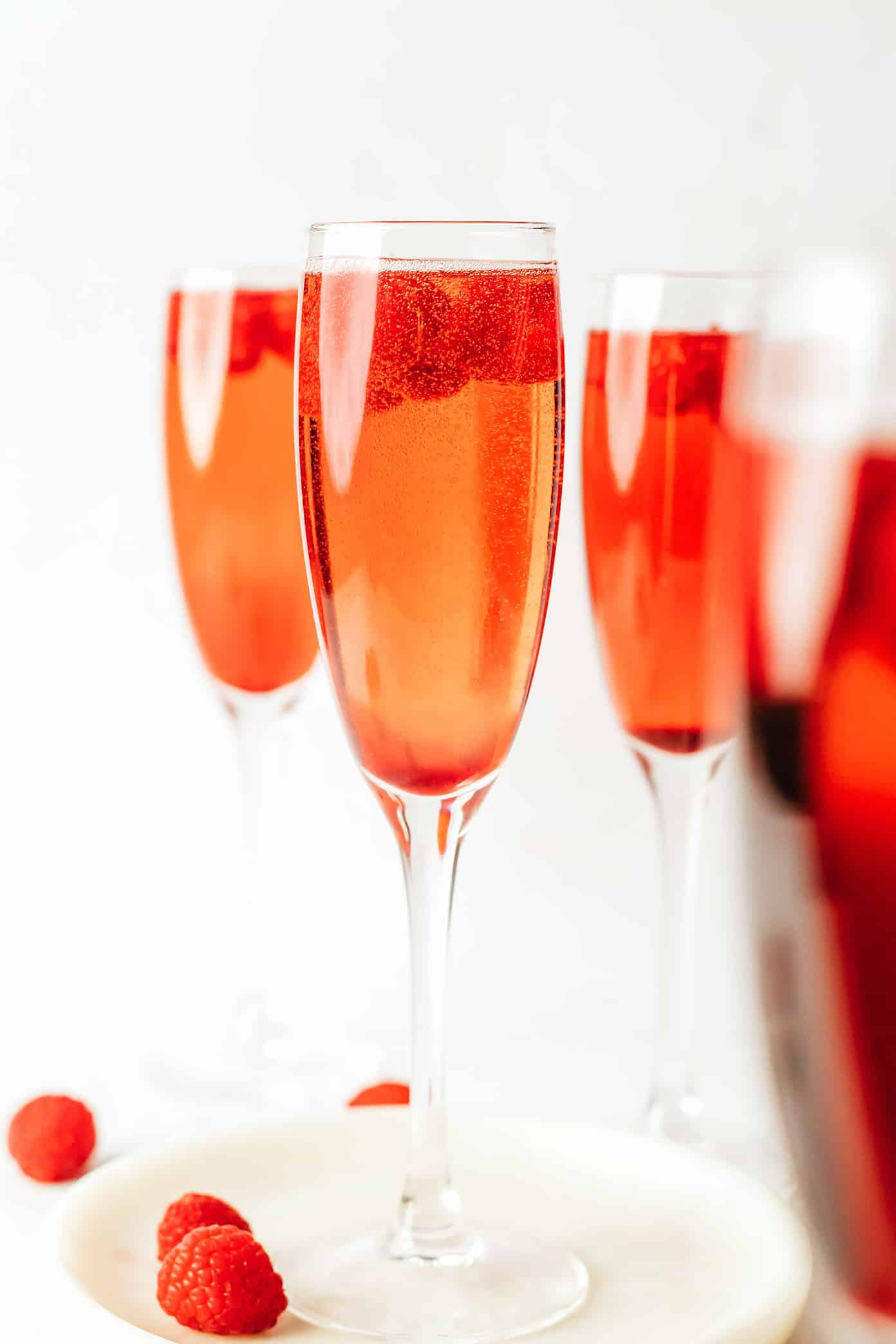 This classic kir royale cocktail recipe is easy to make with dry sparkling wine (such as Champagne, cava or prosecco), crรจme de cassis (blackcurrant liqueur) and your choice of berries for garnish. It's a vibrant, bubbly, refreshing drink that's perfect for summertime! | gimmesomeoven.com Kir Royale with Raspberries