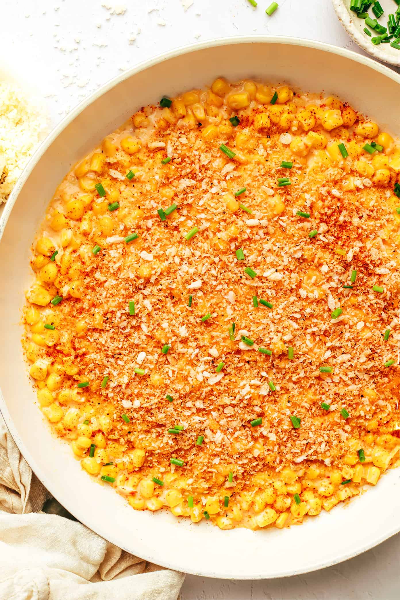 This Parmesan Creamed Corn recipe is layered with sweet and savory flavors, perfectly creamy and cheesy, and sprinkled with irresistible crispy toasted garlic breadcrumbs. Perfect for the holidays, such as Thanksgiving or Christmas, or for any weeknight dinner that needs a simple side dish! | gimmesomeoven.com Parmesan Creamed Corn with Garlicky Breadcrumbs in Pan