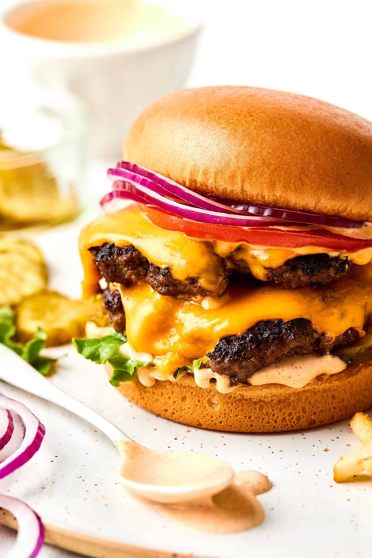 Learn how to make the most juicy, crispy-edged, flavorful homemade smash burgers with this quick and easy recipe. Perfect for easy dinners, grill outs, game day, or anytime you're craving an excellent burger. | gimmesomeoven.com Smash burger with burger sauce