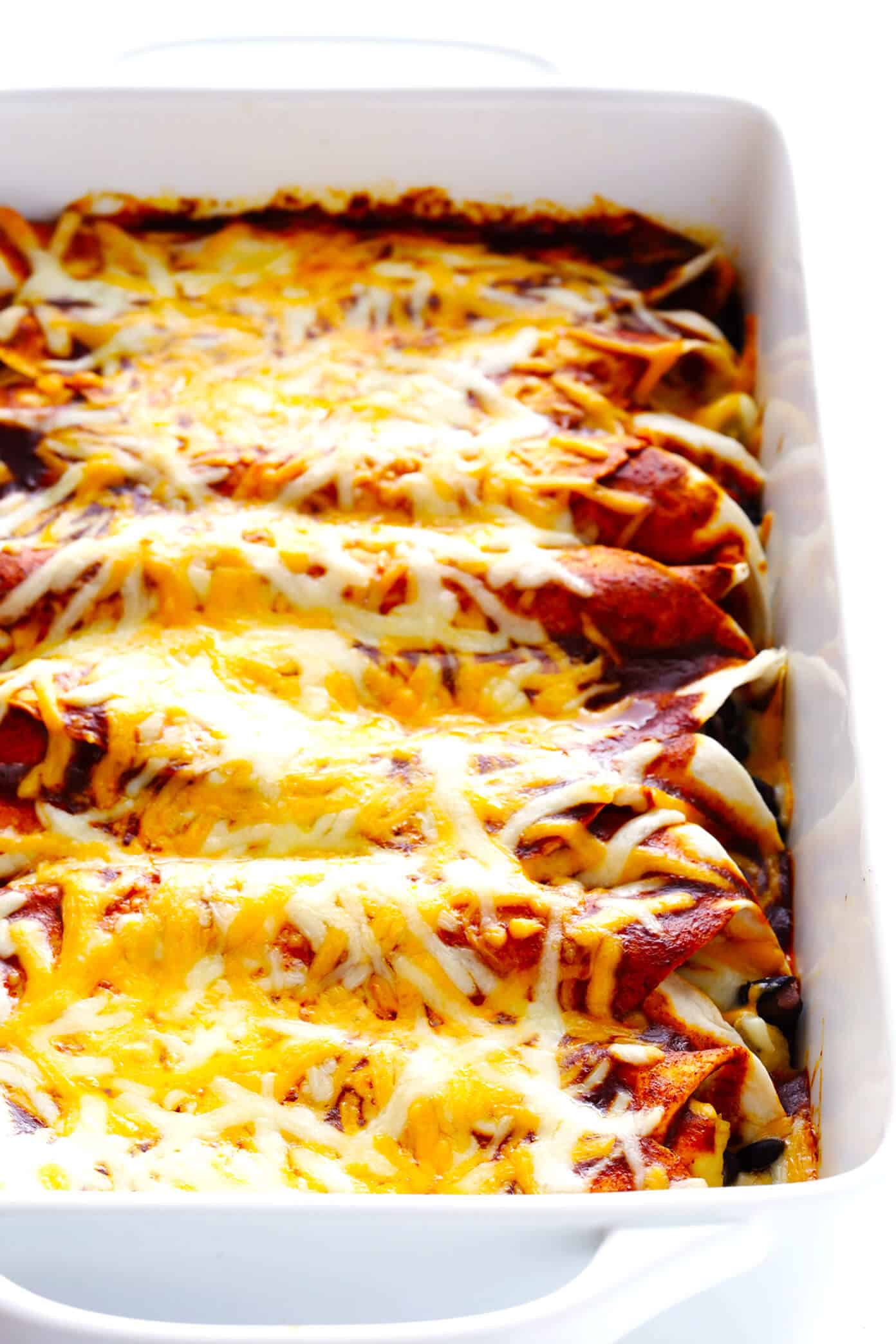 LOVE this easy chicken enchilada recipe! It's made with a delicious homemade enchilada sauce, chicken, cheese, green chiles, beans and whatever other fillings you love most. Always a great recipe when you're craving Mexican (or Tex-Mex) food for dinner -- plus these enchiladas are a great freezer meal for meal prep too. | gimmesomeoven.com Easy Chicken Enchiladas with Cheese