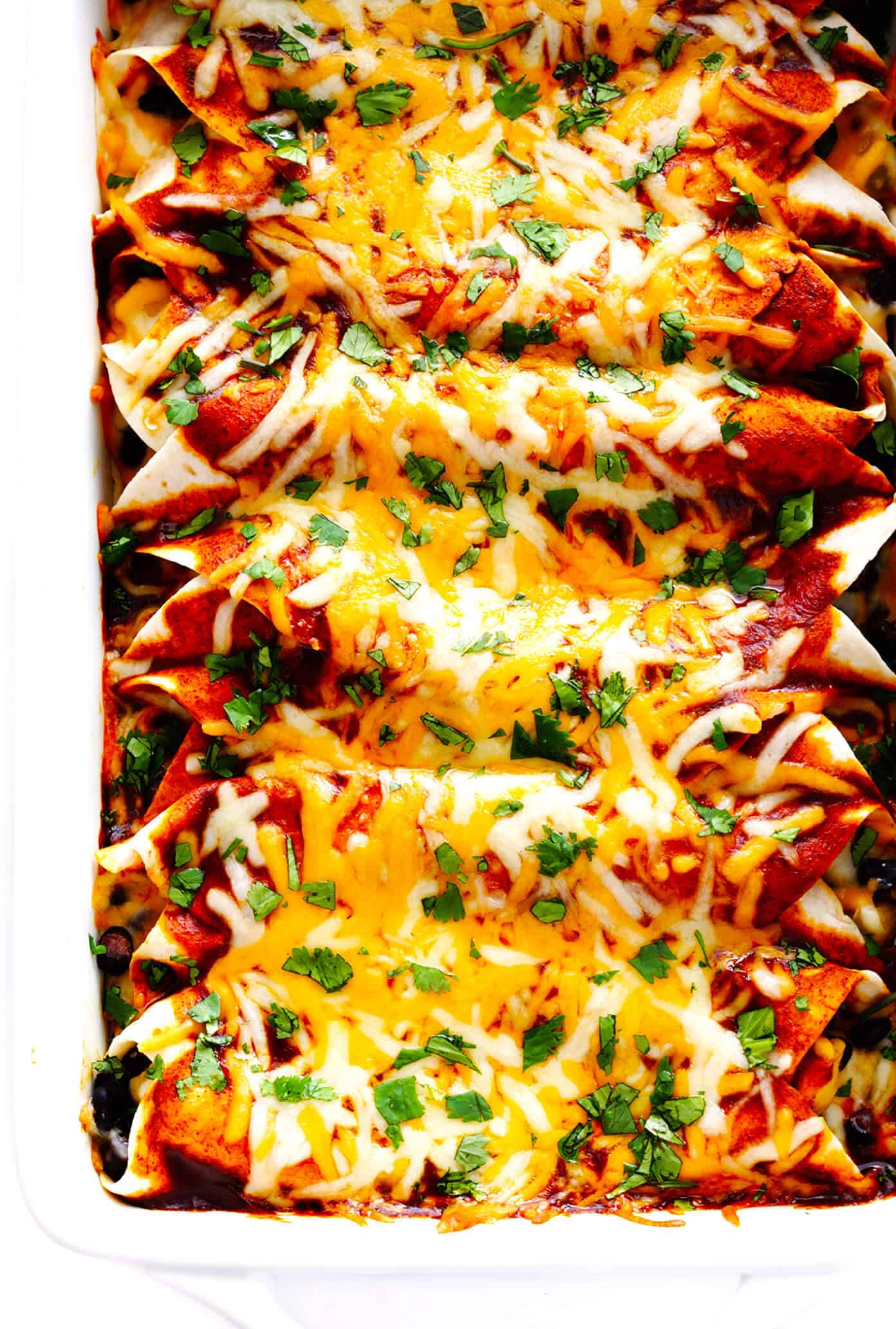 LOVE this easy chicken enchilada recipe! It's made with a delicious homemade enchilada sauce, chicken, cheese, green chiles, beans and whatever other fillings you love most. Always a great recipe when you're craving Mexican (or Tex-Mex) food for dinner -- plus these enchiladas are a great freezer meal for meal prep too. | gimmesomeoven.com Easy Chicken Enchilada Recipe