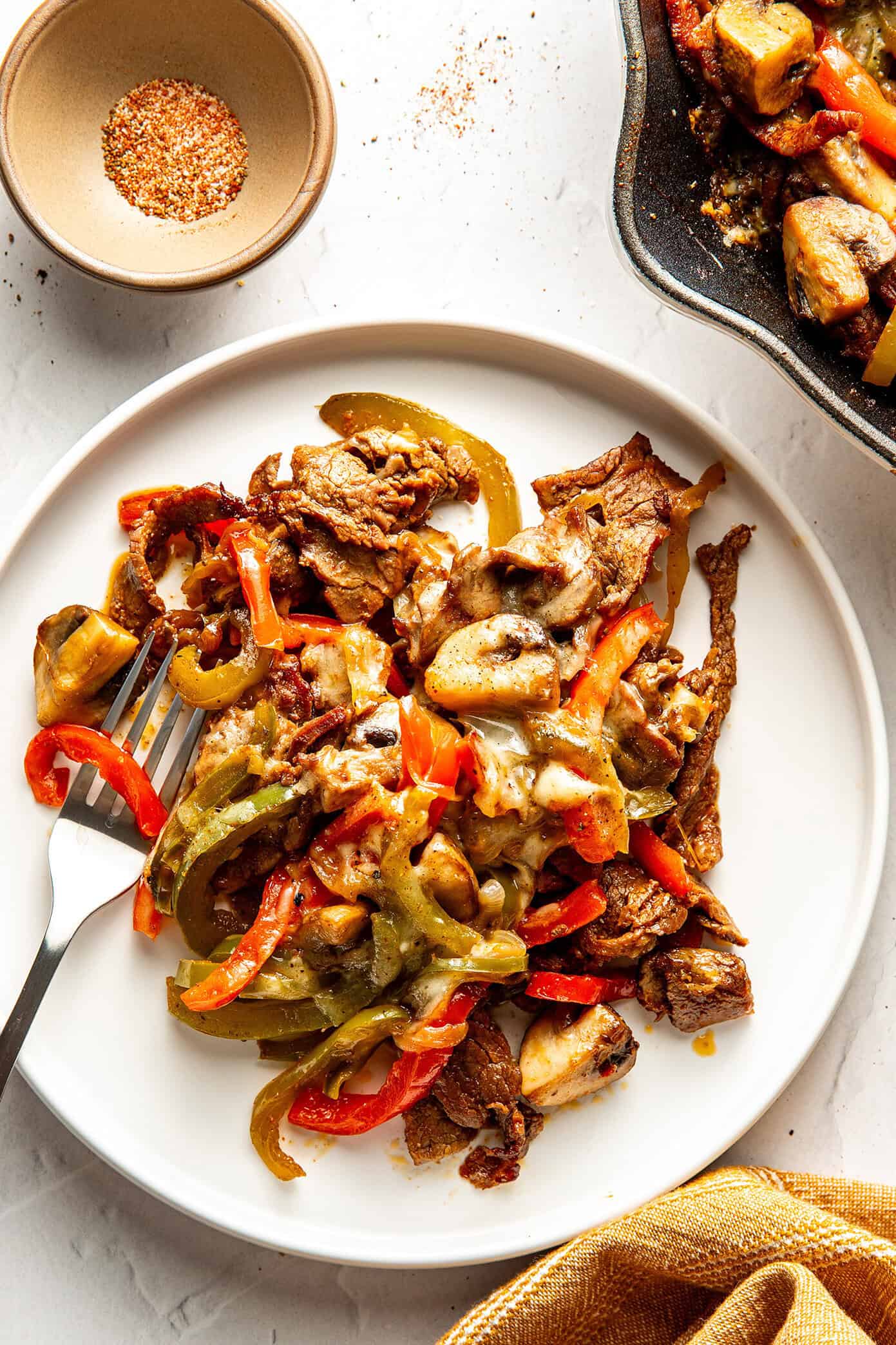 This zesty Philly cheesesteak skillet is a quick and easy one-pan recipe made with tender steak, sautéed veggies, melty provolone, and bold seasonings. Philly cheesesteak skillet serving in pan